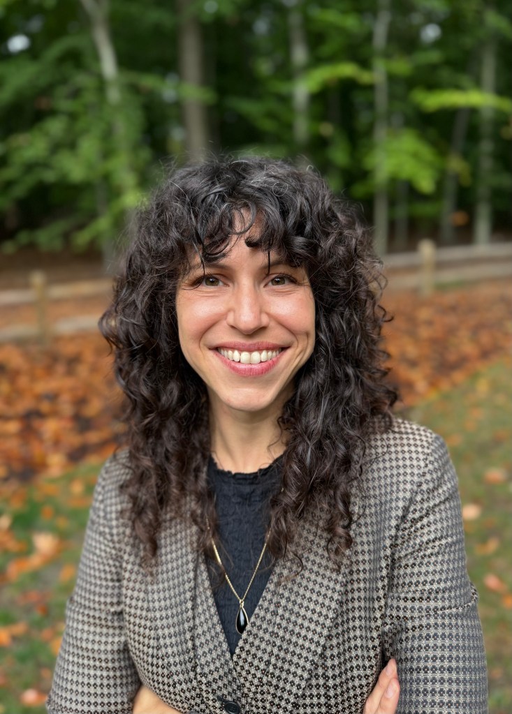 Ariella Werden-Greenfield standing in front of trees. 